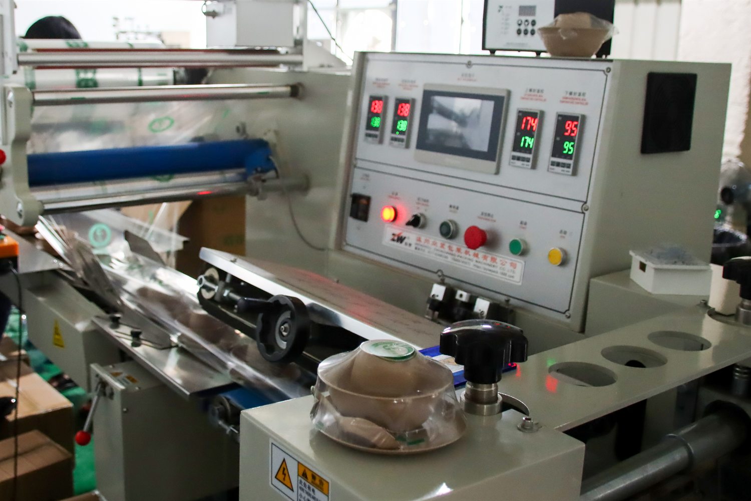 Operator checking eco utensil production line inside factory facility